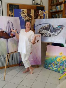 Lucinda Leveille standing in front of some paintings | Lucinda's Studio | Artist | Art Classes | Tutoring | Gold Coast