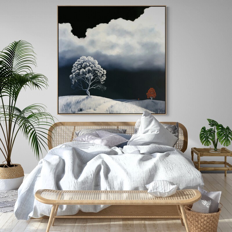 Moonshadows by Lucinda Leveille displayed in a contemporary bedroom interior, original Australian landscape painting featuring a pale solitary tree beneath a luminous cloud and dark atmospheric sky.